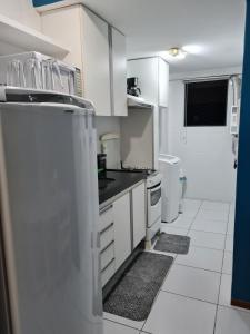 cocina con armarios blancos y nevera en Apartamento Edifício Edécio Lopes, en Maceió