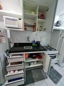 una pequeña cocina con fregadero y microondas en Apartamento Edifício Edécio Lopes, en Maceió