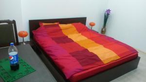a bed with a colorful blanket on a table at Lucy Accommodation in Bucharest