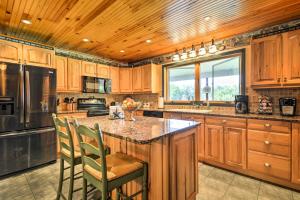 una cucina con armadi in legno e un'isola cucina con sedie di Thompson Home with Deck and Pond, 8 Mi to Elk Mountain a Thompson