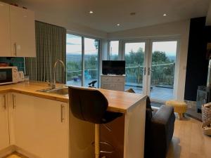 a kitchen with a sink and a counter with a television at Woodside Cabin in Inverness