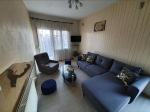 uma sala de estar com um sofá azul e uma mesa em Family friendly apartments with a swimming pool Kastel Novi, Kastela - 18645 em Kaštela