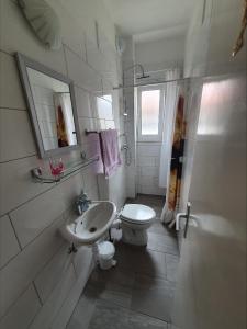 uma casa de banho branca com um lavatório e um WC em Family friendly apartments with a swimming pool Kastel Novi, Kastela - 18645 em Kaštela