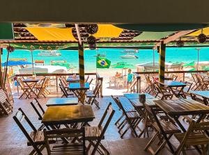 a group of tables and chairs next to the ocean at Beach Point Barra Grande in Maragogi