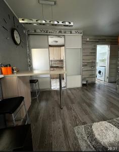 a living room with a table and a mirror at Ахметова 12 in Almaty +1 photo