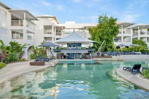 a swimming pool in front of a apartment building at Mantra PortSea in Port Douglas