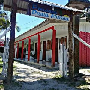 ein rot-weißes Gebäude mit einem Schild darauf in der Unterkunft Pousada Praia Mansa Superagui in Superagui