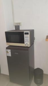 a microwave oven sitting on top of a refrigerator at Monoambiente in Mercedes