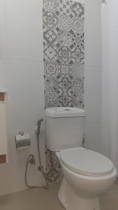 aseo blanco en un baño con pared de azulejos en Monoambiente, en Mercedes