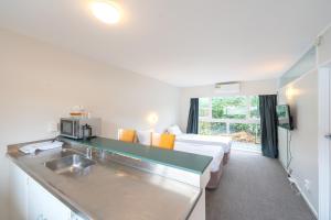 a hotel room with a kitchen and a bed in it at Ranfurly Evergreen Motel in Auckland