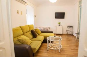 sala de estar con sofá amarillo y mesa en Apartamento deluxe Terraza y bbq, en Santa Amalia