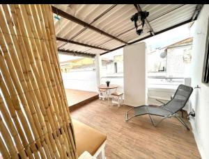 ein Wohnzimmer mit einem Stuhl und einem Schreibtisch in der Unterkunft Apartamento deluxe Terraza y bbq in Santa Amalia
