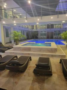 ein großer Pool mit Liegestühlen in einem Gebäude in der Unterkunft Hotel Cayuga in Puntarenas