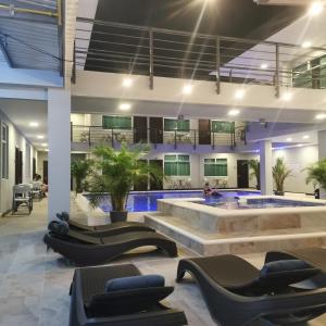 eine Lobby mit einem Pool und Liegestühlen in der Unterkunft Hotel Cayuga in Puntarenas