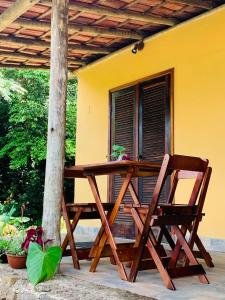 a wooden table and a chair on a porch at Fauna in Praia do Bananal