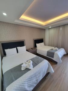 ein Hotelzimmer mit 2 Betten mit Blumen darauf in der Unterkunft Hotel Cayuga in Puntarenas