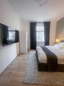- une chambre avec un grand lit et une fenêtre dans l'établissement Modern Cozy apt. -with 2 TV, Netflix and work desk, à Essen