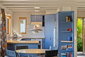 a kitchen with blue cabinets and a table and chairs at Whakatipu Heights in Queenstown