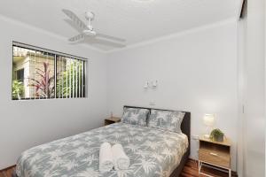 a white bedroom with a bed and a window at Allamanda Unit 22 in Long Jetty