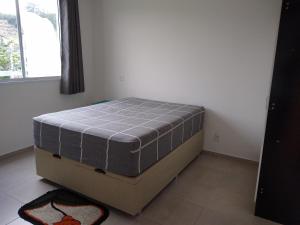 una cama en una esquina de una habitación en Condomínio Ilha do Sol, en Florianópolis