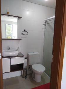 a bathroom with a toilet and a sink and a shower at Condomínio Ilha do Sol in Florianópolis