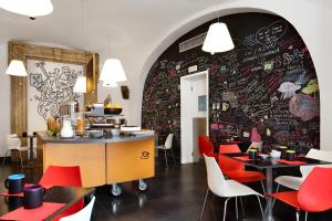 un ristorante con sedie rosse e un muro con graffiti di Hotel Piazza Bellini & Apartments a Napoli