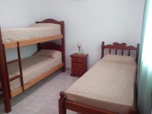 a bedroom with two bunk beds and a night stand at Sierras de los Nietos in Potrero de los Funes