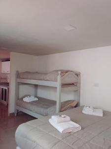 ein Schlafzimmer mit zwei Etagenbetten mit Handtüchern darauf in der Unterkunft Antü in Puerto Pirámides