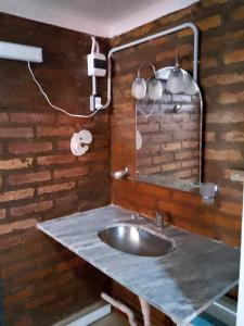uma casa de banho com um lavatório e um espelho em Antü em Puerto Pirámides