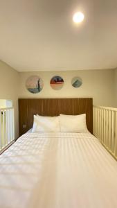 1 cama blanca en un dormitorio con 2 cuadros en la pared en Nadika Homes Private Pool, en Karangploso