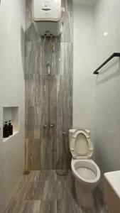 y baño con aseo y cabina de ducha. en Nadika Homes Private Pool, en Karangploso
