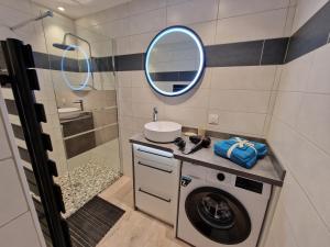 a bathroom with a washing machine and a mirror at Le temps d'un rêve, Cannes appart 4 pers in Cannes