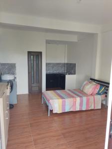1 dormitorio con 1 cama y suelo de madera en Keneth Hostel, 