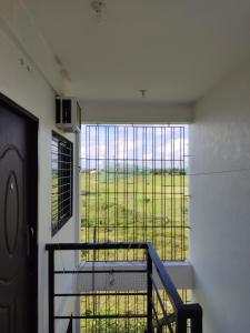 uma varanda com uma grande janela com vista para um campo em Keneth Hostel 