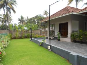 a house with a green lawn in front of it at EV StayZ in Cherai Beach