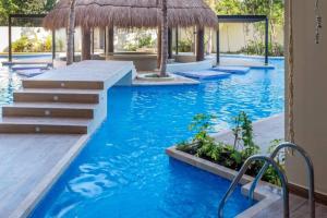 una piscina de agua azul y un complejo en CRlSTALIDA Swim up & free bikes by Casa Paraiso, en Tulum