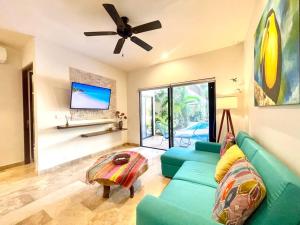sala de estar con sofá verde y ventilador de techo en CRlSTALIDA Swim up & free bikes by Casa Paraiso, en Tulum
