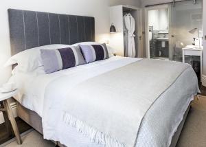 ein Schlafzimmer mit einem großen weißen Bett mit lila Kissen in der Unterkunft Brocco On The Park Boutique Hotel in Sheffield