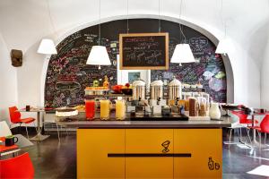 a restaurant with a yellow counter with food on it at Hotel Piazza Bellini & Apartments in Naples