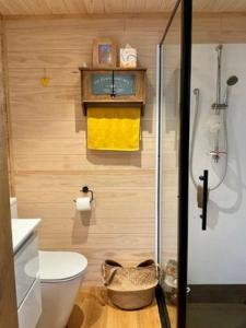 bagno con servizi igienici, doccia e asciugamano giallo di Are Mii a stylish one room container home a Rarotonga