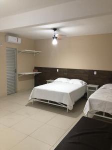 a bedroom with two beds in a room at Condomínio Recanto dos Dourados - Kitnet in Três Marias +6 photos