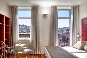 a bedroom with a bed and a large window at Hotel Piazza Bellini & Apartments in Naples