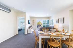 a dining room and living room with a table and chairs at Pacific Blue 278-265 Sandy Pt Rd- Dual Key Access, Wifi, Linen and Air Conditioning in Salamander Bay