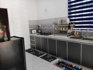 a kitchen with a sink and a counter top at Homestay Pinang Tunggal in Sungai Petani