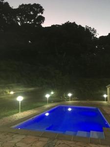 ein großer blauer Pool in der Nacht mit Lichtern in der Unterkunft Les Lucioles 2 Beau T3 en forêt tropicale avec piscine in Saint-Joseph