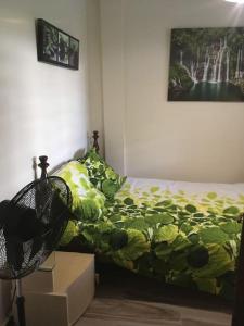 ein Schlafzimmer mit einem Bett mit einer grünen Bettdecke und Kisten in der Unterkunft Les Lucioles 2 Beau T3 en forêt tropicale avec piscine in Saint-Joseph