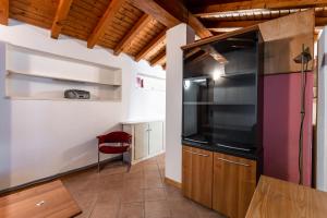una cocina con armarios de madera y una silla roja en Pina's House - by Host4U, en Gussago