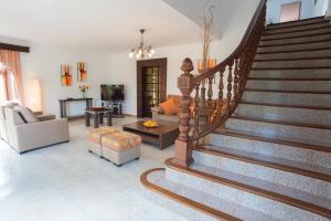 a living room with a staircase with a couch and a living room at Villa Dos Pinos in Cala d´Or