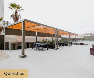 a pavilion with tables and chairs on a patio at La herradura departamento nuevo a pasos de la playa 2 dorm 1 baño in Coquimbo