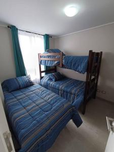 a bedroom with two bunk beds and a bed at La herradura departamento nuevo a pasos de la playa 2 dorm 1 baño in Coquimbo